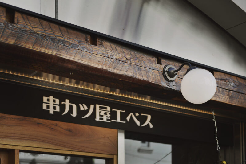 大工の手仕事が刻まれた古木が出迎える入り口