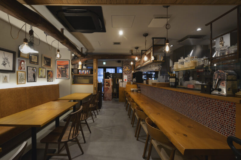 店内は、カウンター席と壁際のテーブル席で構成された、奥行きのある空間。