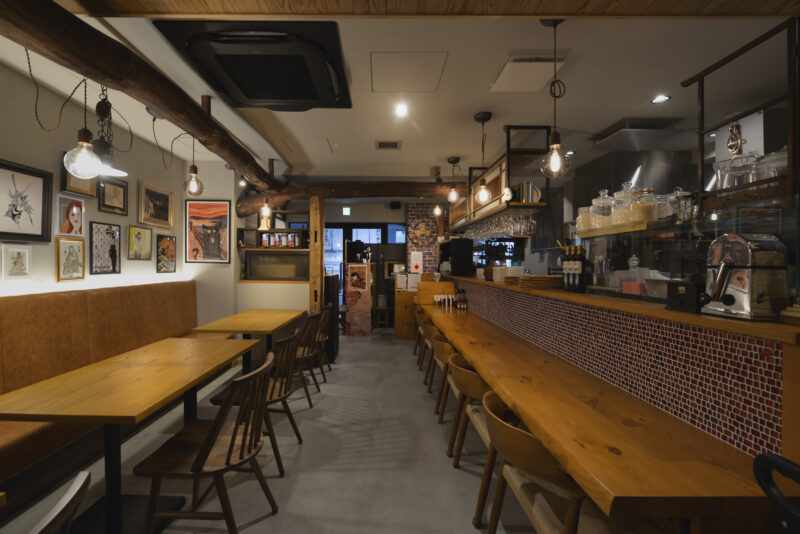 店内は、カウンター席と壁際のテーブル席で構成された、奥行きのある空間。