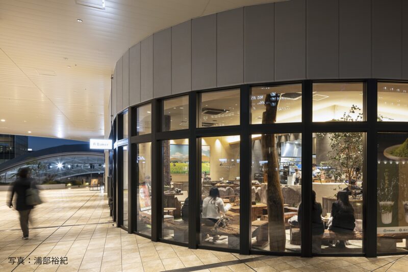 店舗外観。奥にうめきた公園の大屋根（設計：SANAA）が見える。